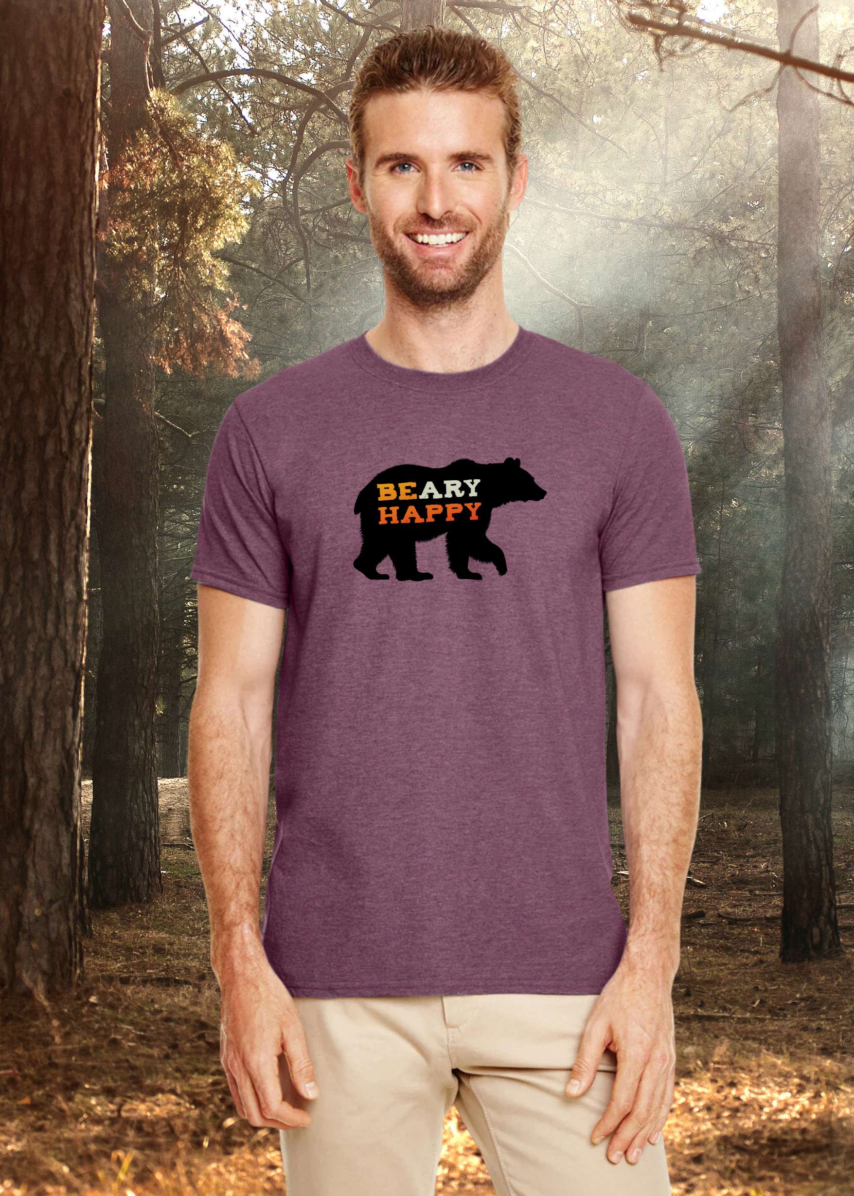 Man wearing a purple t-shirt with a bear graphic and 'BEAR HAPPY' text in a forest setting