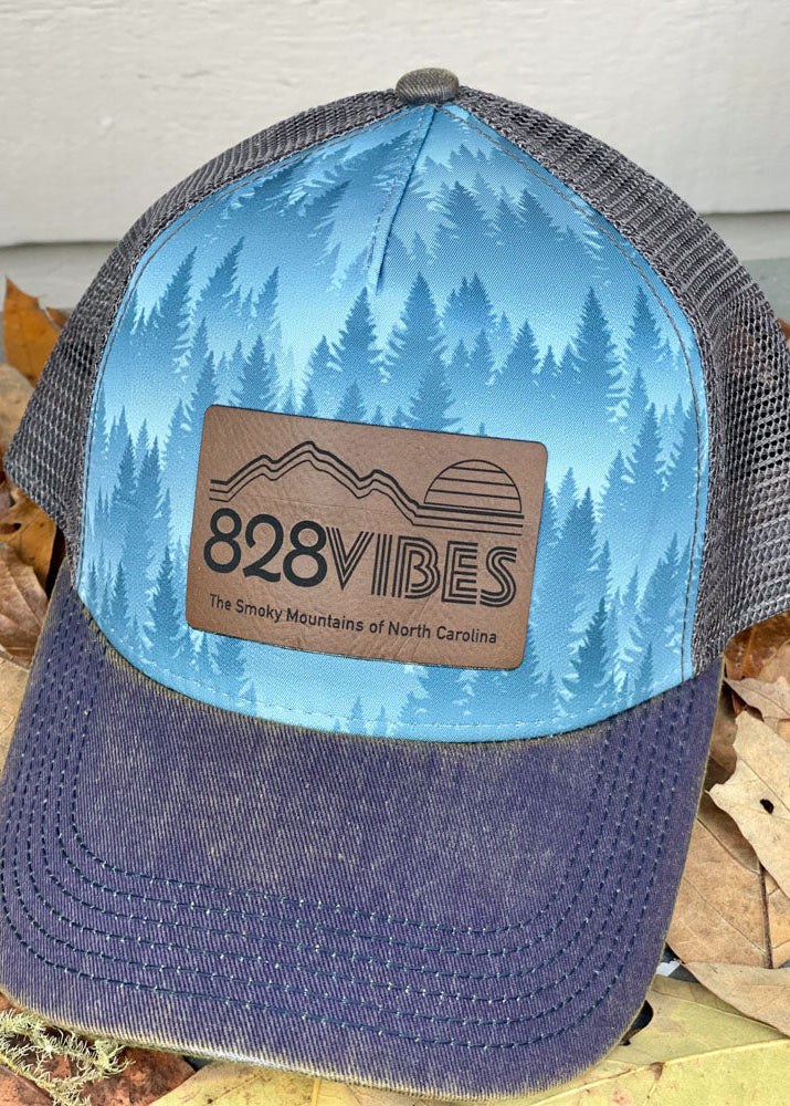 Trucker hat with '828 Vibes' logo on a background of leaves