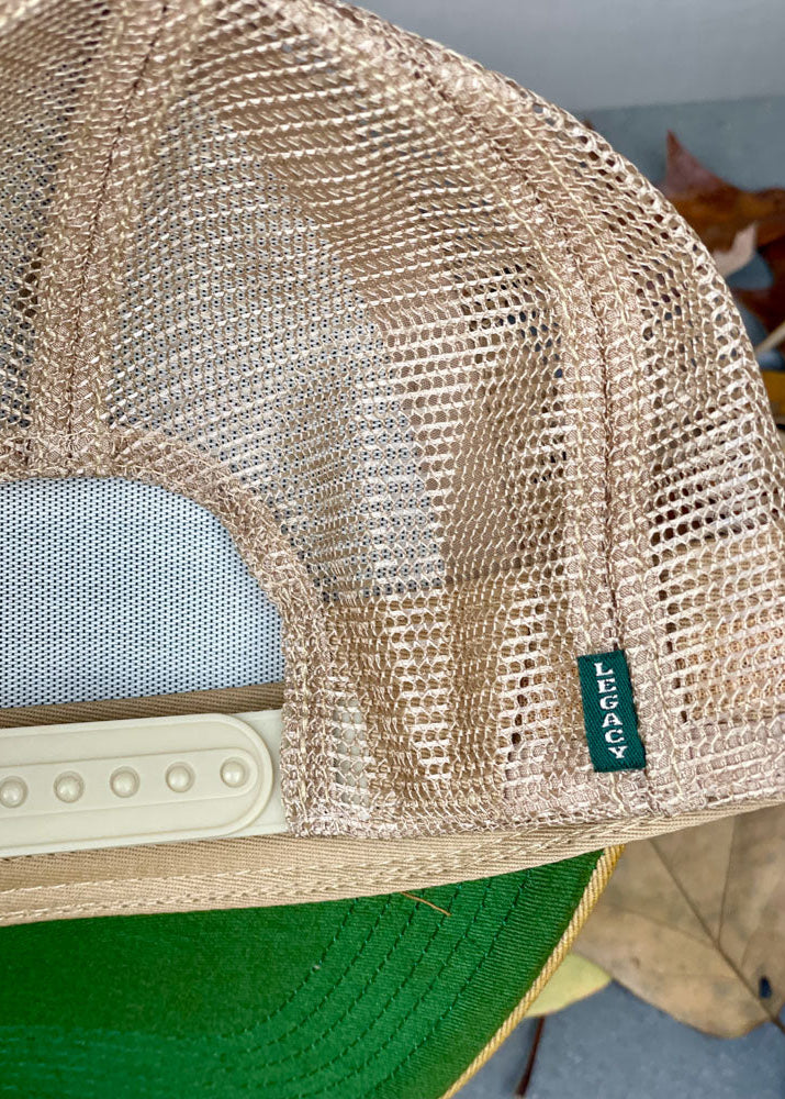 Beige mesh cap with a brand logo on a blurred background