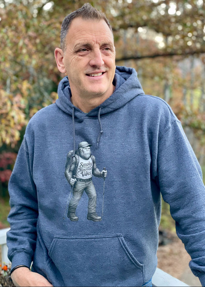 Man wearing a blue hoodie with a graphic design outdoors