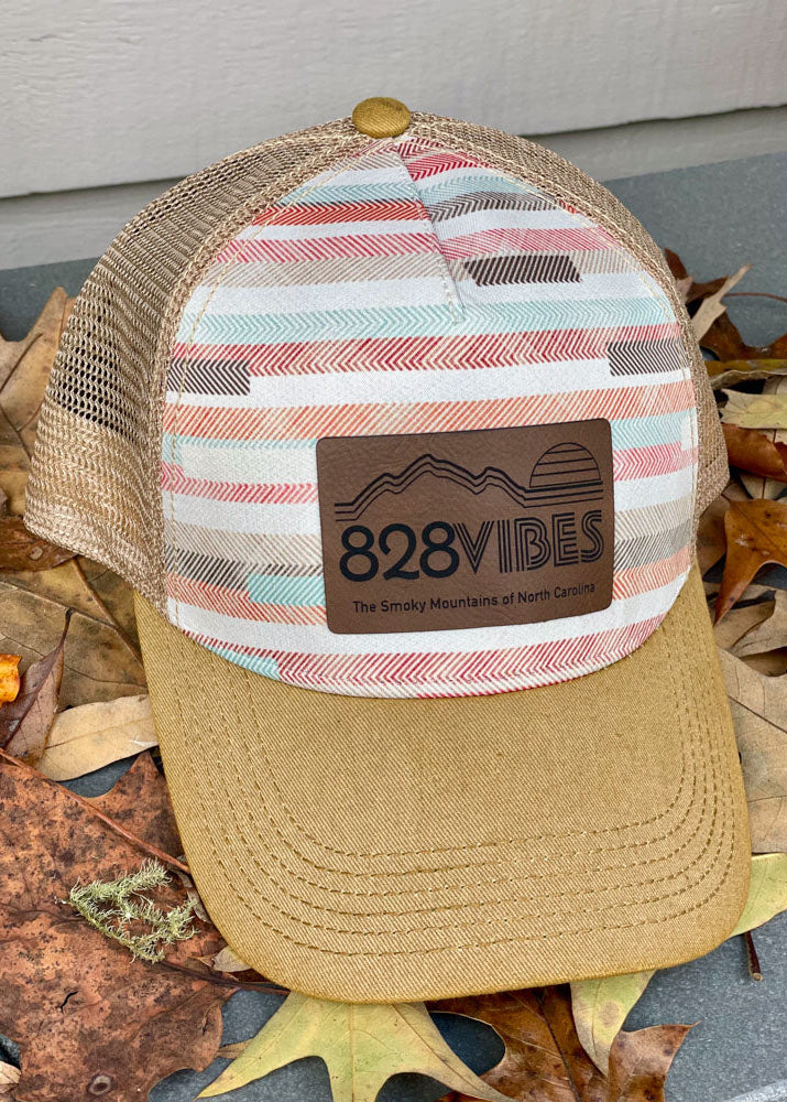 Stripped cap with '828VIBES' logo on a leafy background