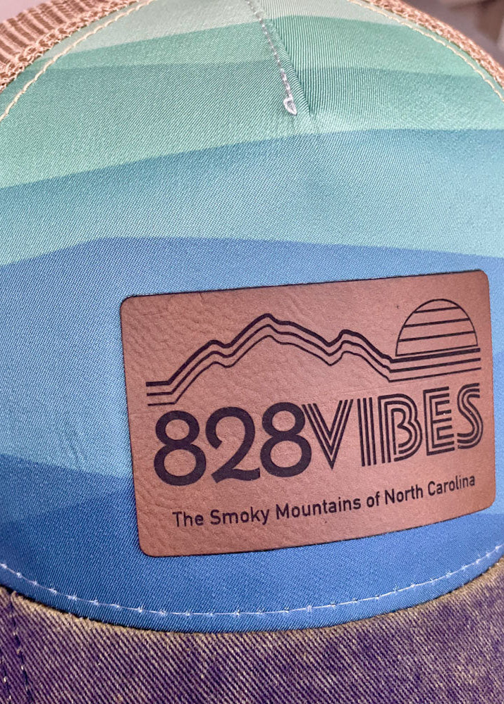 Colorful cap with a '828 Vibes' logo and text on a blurred background